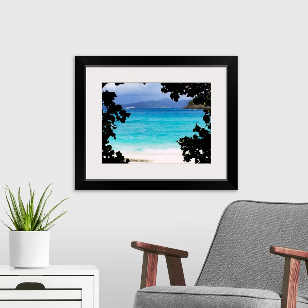 A modern room featuring Large photograph shows the clear water of a beach in Cinnamon Bay through a silhouetted outline o...