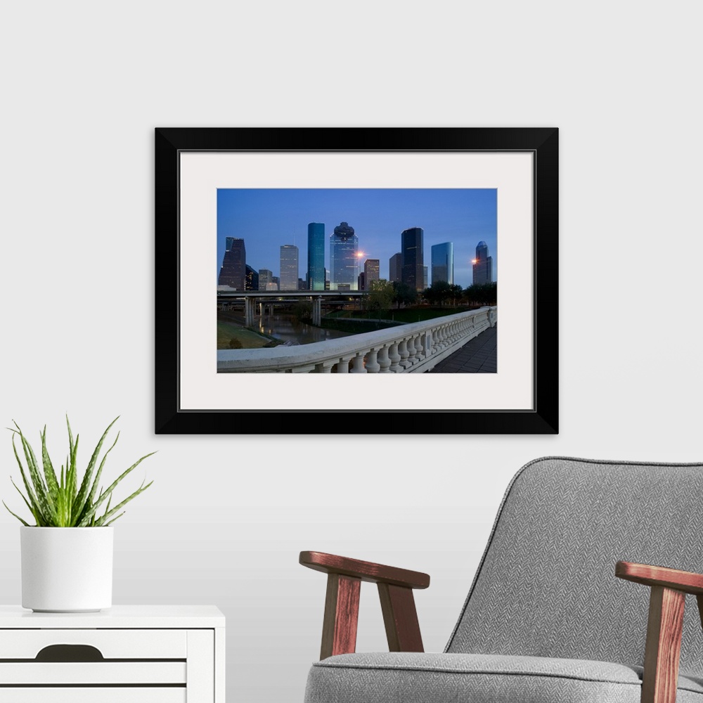 A modern room featuring Street view photograph of tall buildings lit up in a city at dusk.