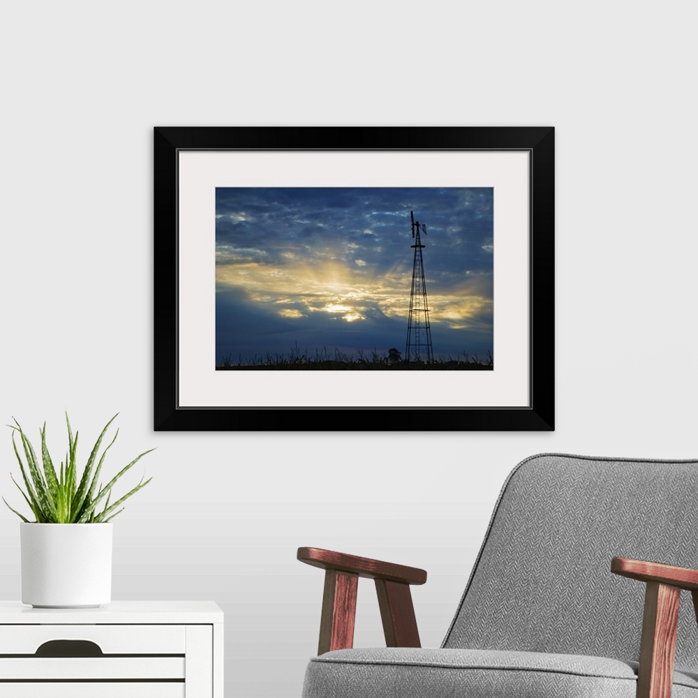 A modern room featuring Sunset light through heavy clouds, silhouetted windmill, Iowa