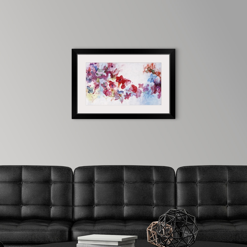 A modern room featuring Large horizontal artwork of colorful flowers of red, pink and blue fading into the white background.