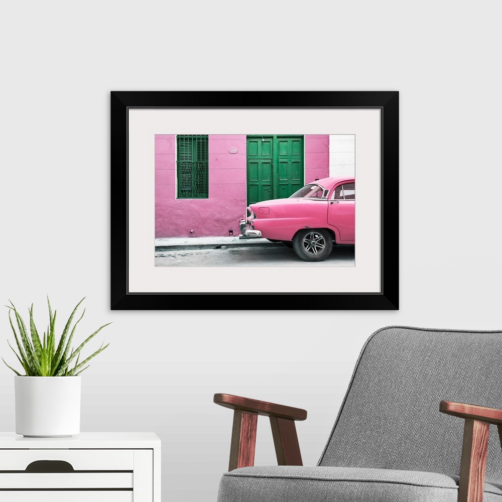 A modern room featuring Photograph of the back of a pink vintage car next to a matching facade with a green wooden door a...