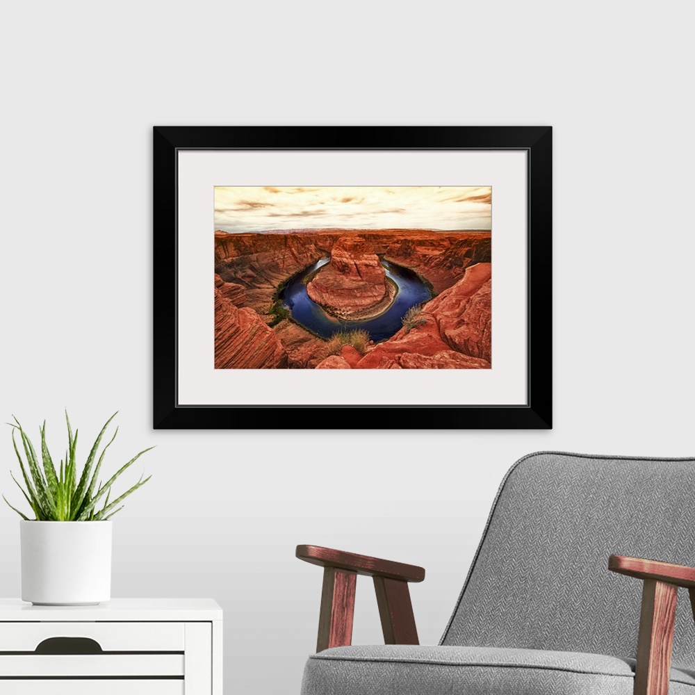 A modern room featuring Fine art photograph of Horseshoe Bend in the Arizona landscape under a pale cloudy sky.
