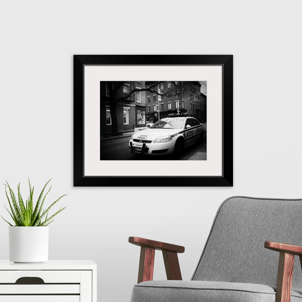 A modern room featuring A black and white photograph of an NYPD police car in New York city.