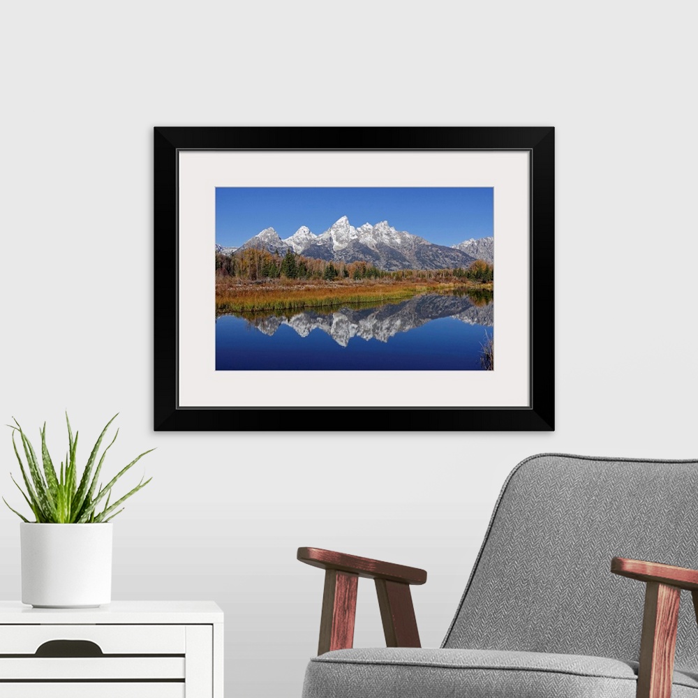 A modern room featuring The Grand Tetons reflected on the Snake river near Jackson, Wyoming.