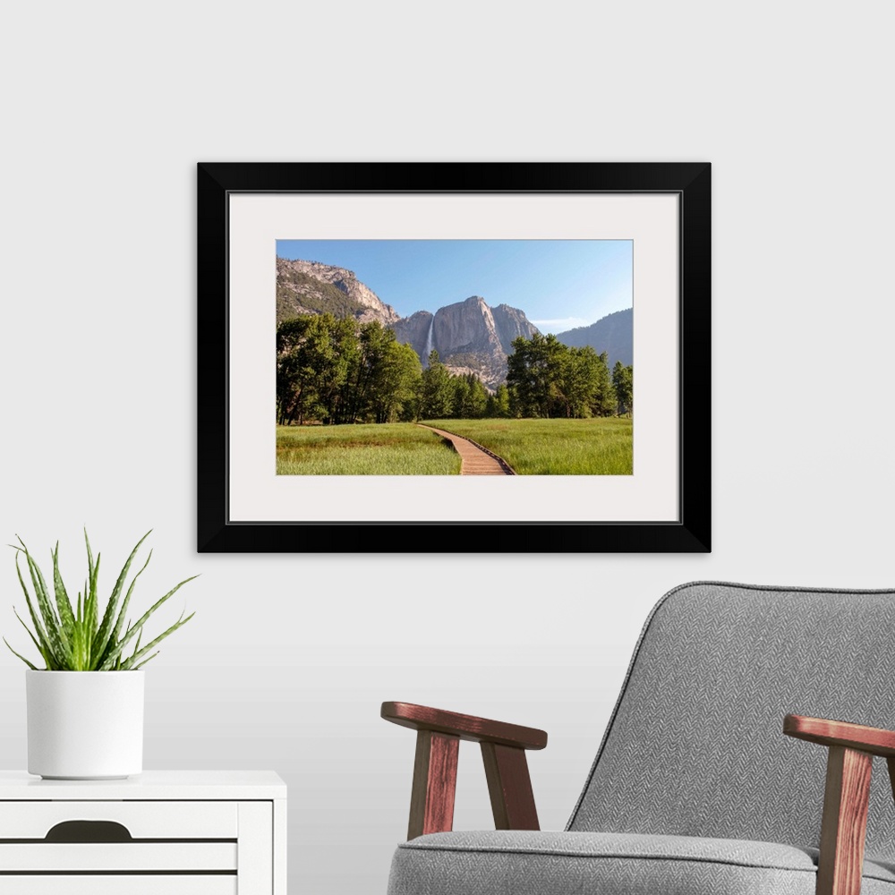 A modern room featuring View of wooden pathway with Yosemite Falls in the background, Yosemite National Park, California.