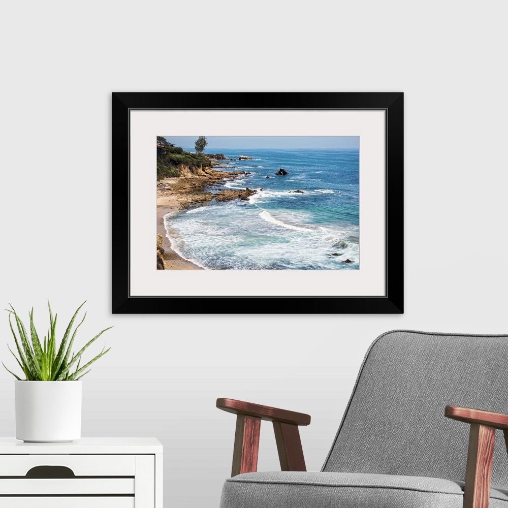 A modern room featuring Little Corona del Mar beach is relatively small, flanked on both sides with rocky reefs.