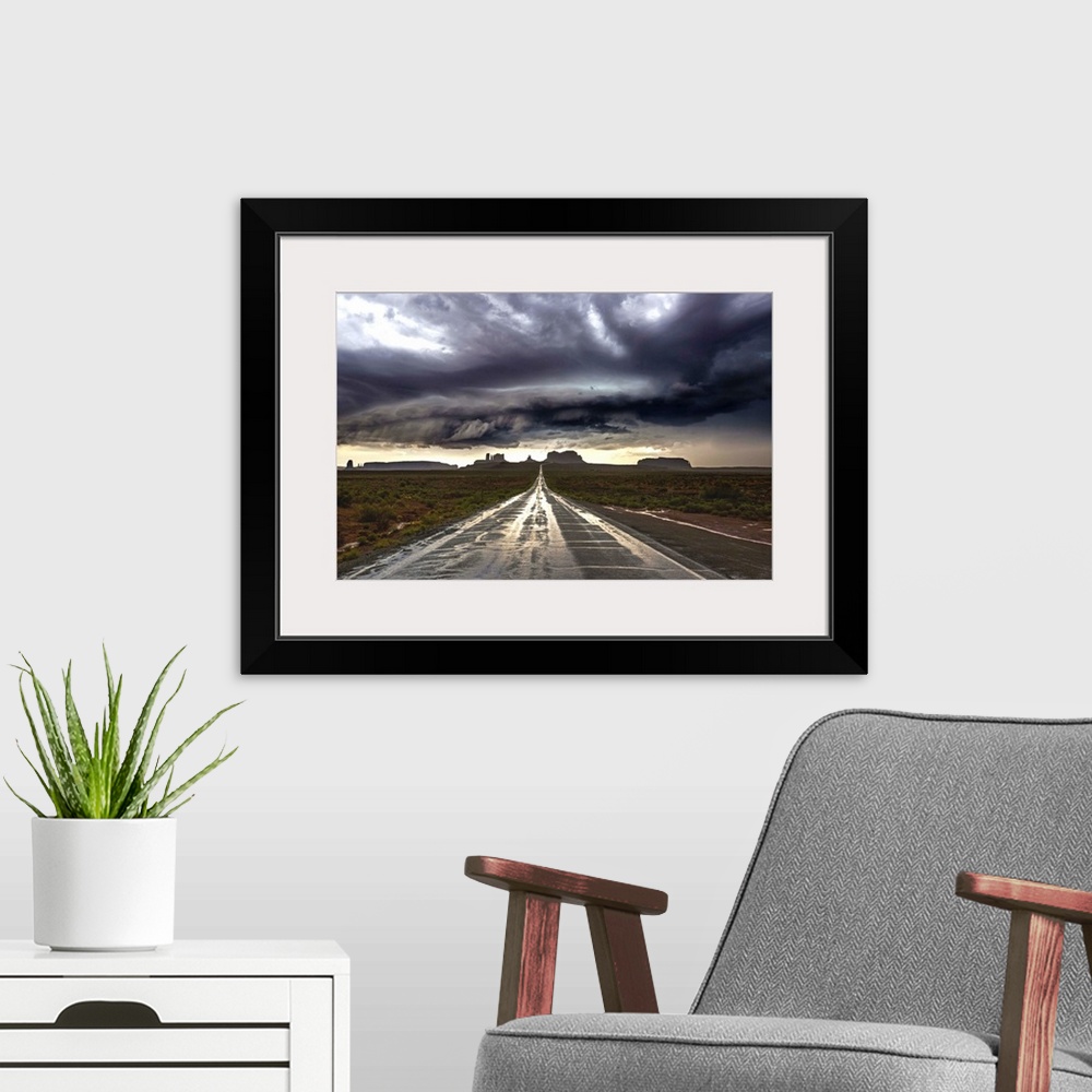 A modern room featuring Photograph of Monument Valley with dramatic clouds above taken from a wet road after a storm.