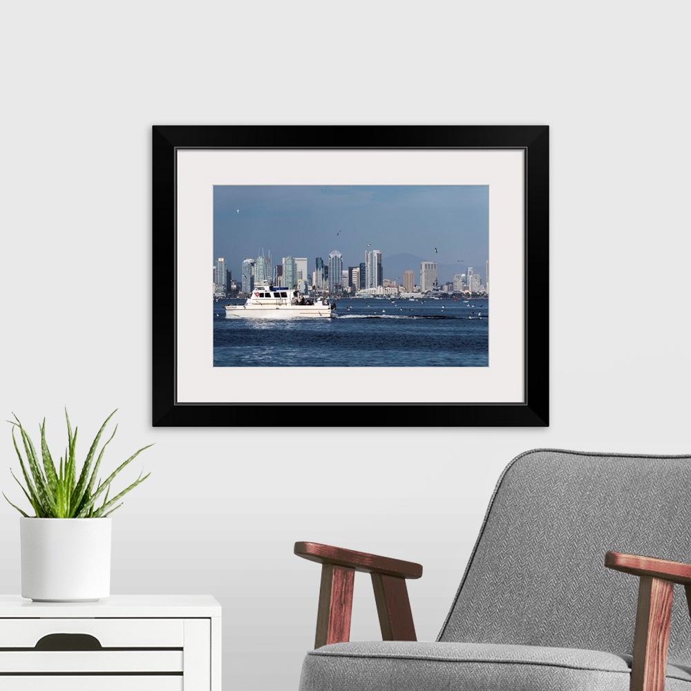 A modern room featuring Photograph of a charter fishing boat on the Pacific Ocean with seagulls flying around it and the ...