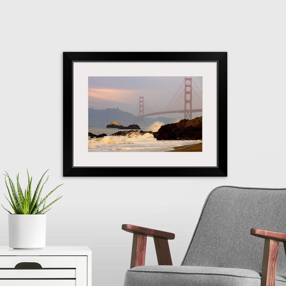 A modern room featuring From the National Geographic Collection a landscape photograph of waves crashing on a rocky shore...