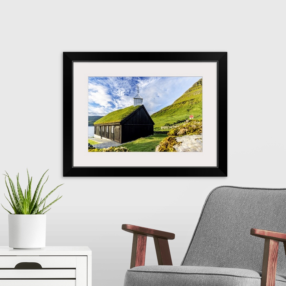 A modern room featuring Traditional church with grass roof overlooking the fjord, Funningur, Eysturoy Island, Faroe Islan...