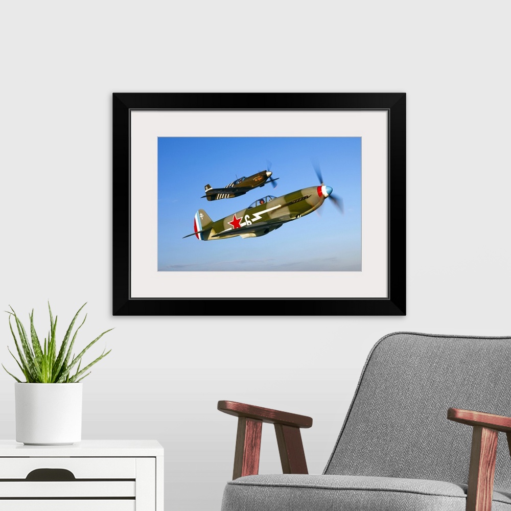 A modern room featuring A Soviet Yakovlev Yak-3 and a P-51A Mustang in flight over Chino, California.