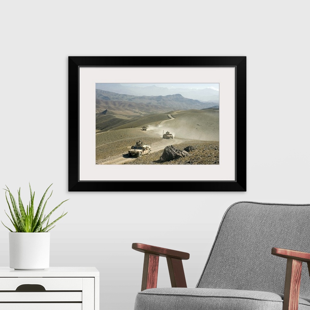 A modern room featuring Humvees traverse rugged mountain roads