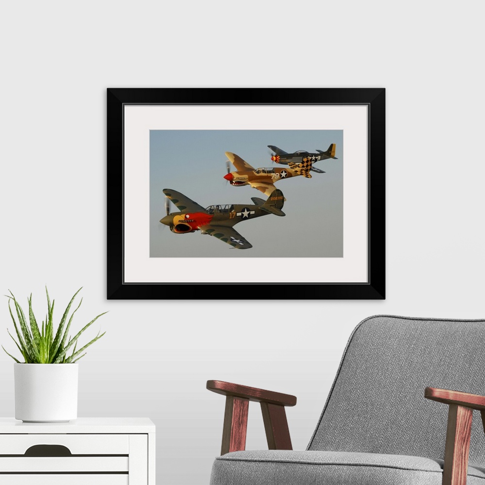 A modern room featuring Two P-40 Warhawks and a P-51D Mustang flying over Chino, California.