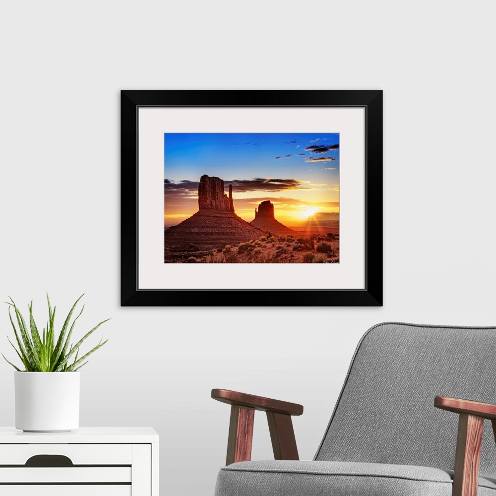 A modern room featuring Landscape photograph of the buttes at Monument Valley in Arizona with a bright sunset in the back...