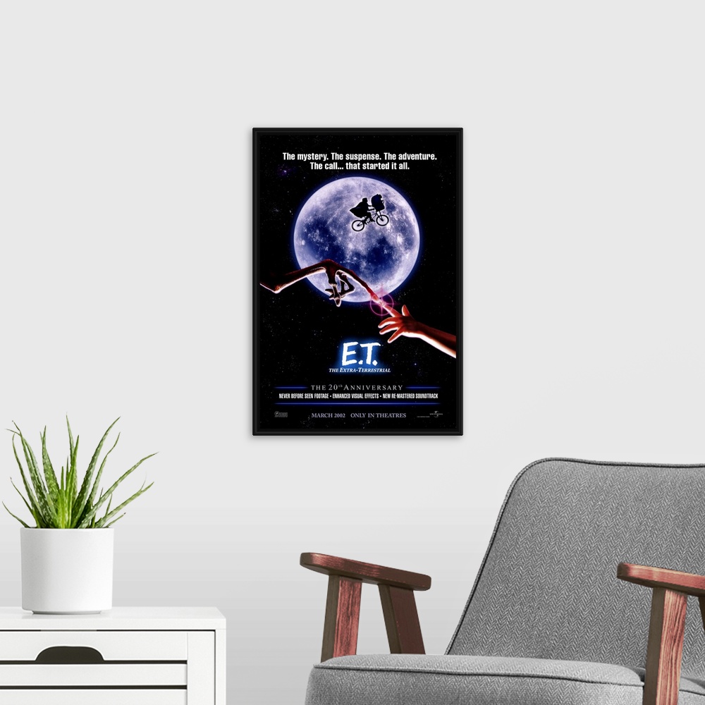 A modern room featuring A large vertical print of the 20th anniversary poster of E.T. It depicts the famous scene of the ...