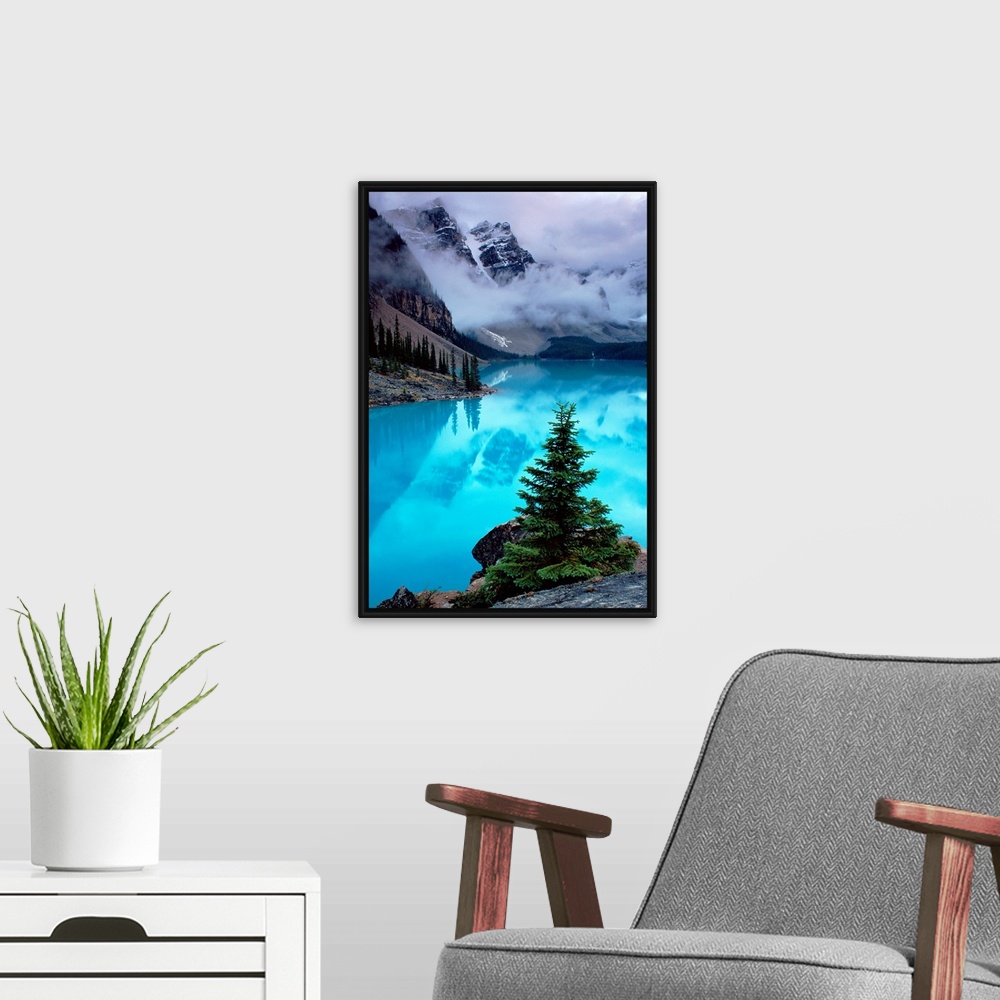 A modern room featuring From the National Geographic Collection a photograph of mountains reflecting in water as clouds p...