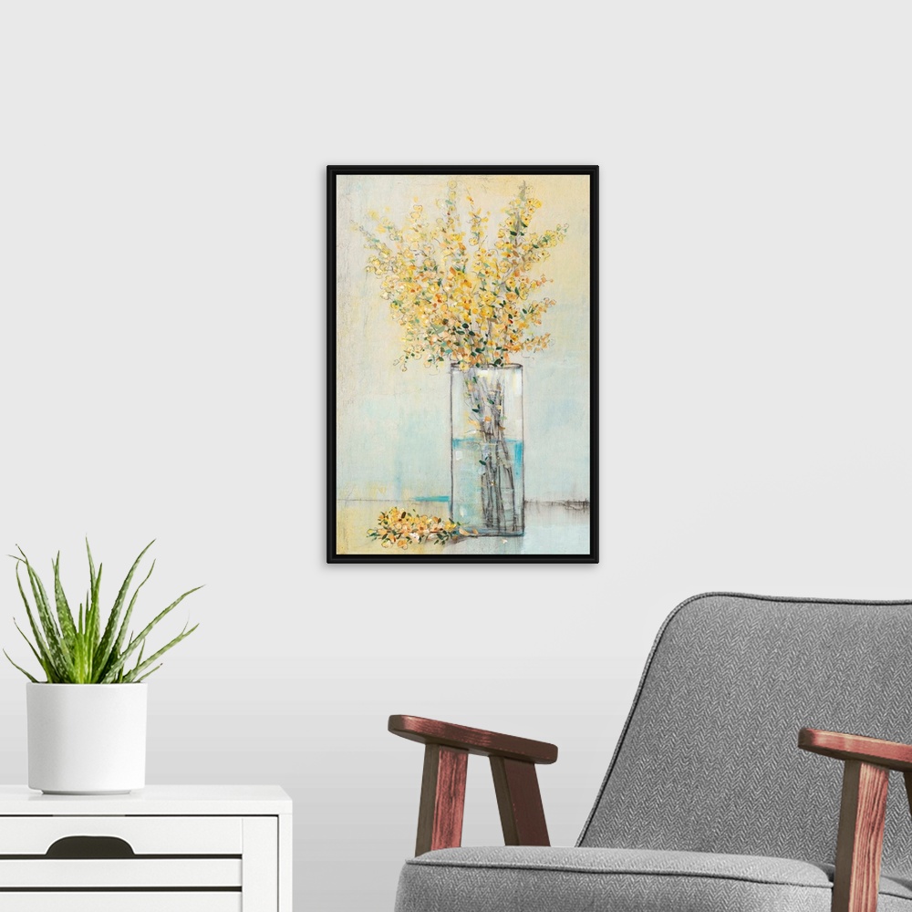 A modern room featuring Yellow flowers sitting in a rectangular glass vase.