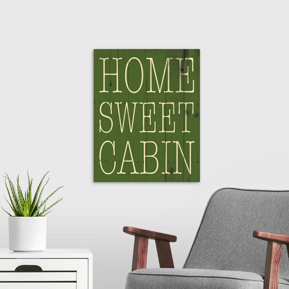 A modern room featuring Typographical artwork with "Home sweet cabin" in a thin rustic text.