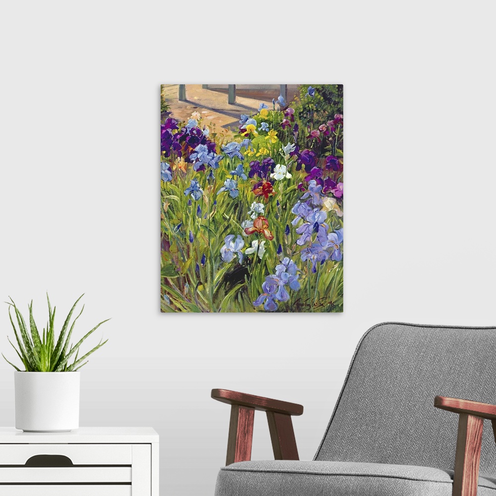 A modern room featuring Oil painting by Timothy Easton featuring colorful iris flowers blooming in a garden.