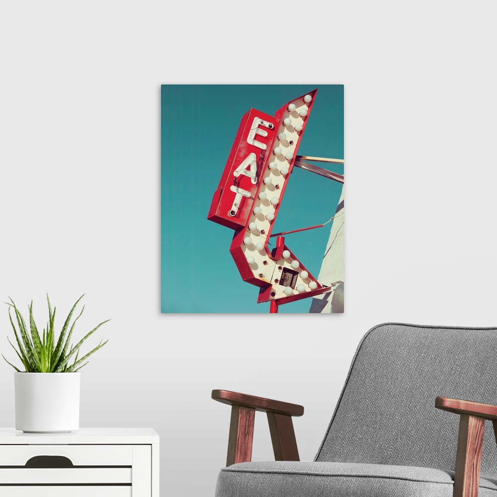 A modern room featuring Photograph of a vintage red and white light up 'EAT' sign with an arrow on a blue sky background.