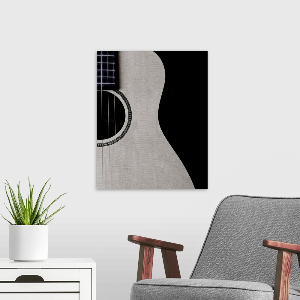 A modern room featuring Black and white photograph of half a guitar highlighting its curves.