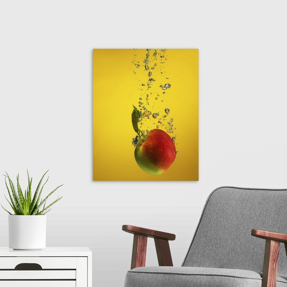 A modern room featuring An apple splashed into water, creating bubblessplash. on yellow backdrop
