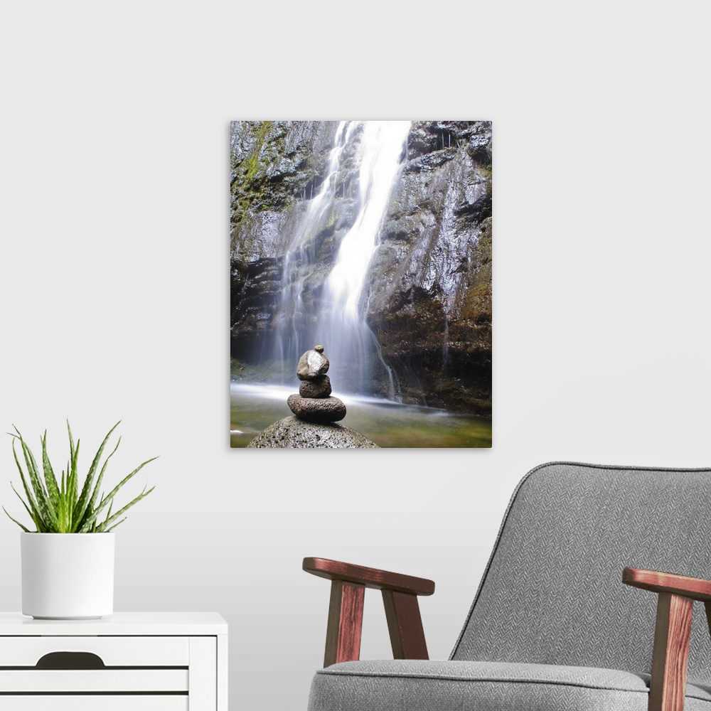 A modern room featuring Stack of polished stones in front of a waterfall.
