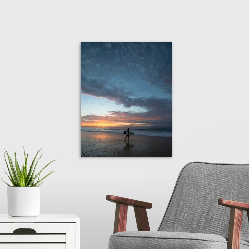A modern room featuring Surfer walking on the beach at sunset, Hawaii, USA