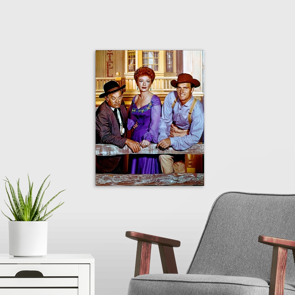 A modern room featuring Cast members Milburn Stone, Amanda Blake, and Dennis Weaver in a publicity photograph for the tel...
