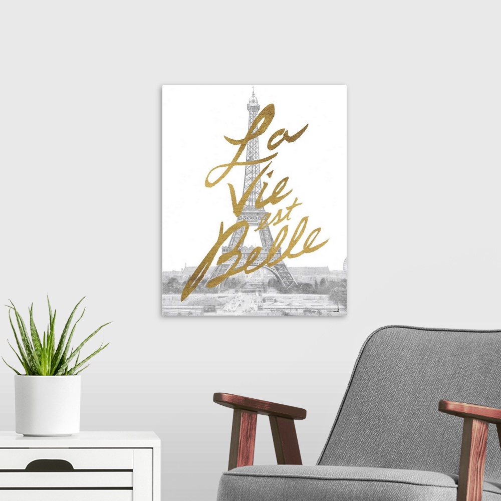 A modern room featuring Gold handlettering against a muted black and white photograph of the Eiffel Tower in Paris.