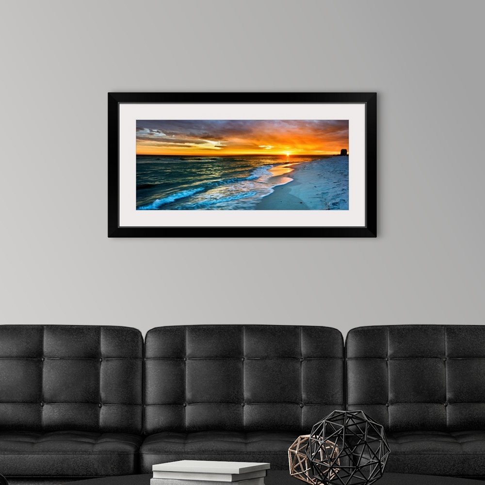 A modern room featuring A dark beach before a panoramic orange sunset with a burning red sky. Landscape taken on Navarre ...