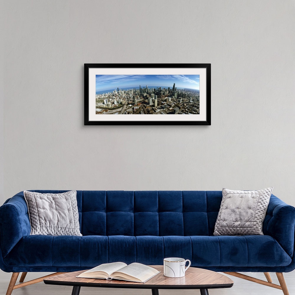 A modern room featuring The city of Chicago is photographed from up high showing almost all of the skyscrapers and a larg...