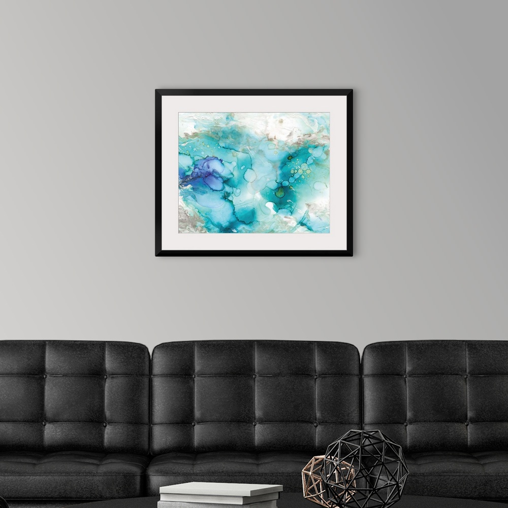 A modern room featuring Large abstract watercolor painting in shades of blue, grey, and green marbling together.