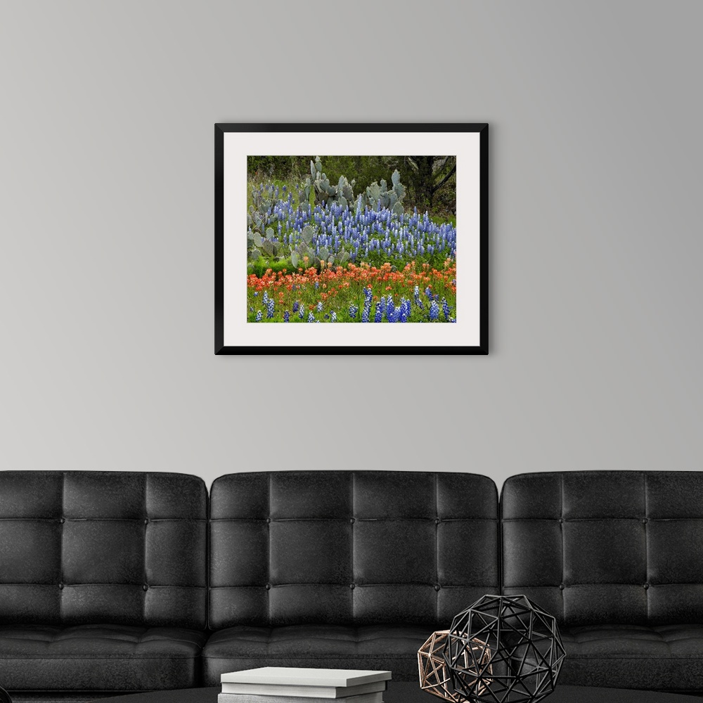 A modern room featuring A large decorative piece of wildflowers in a field with cactus intertwined.