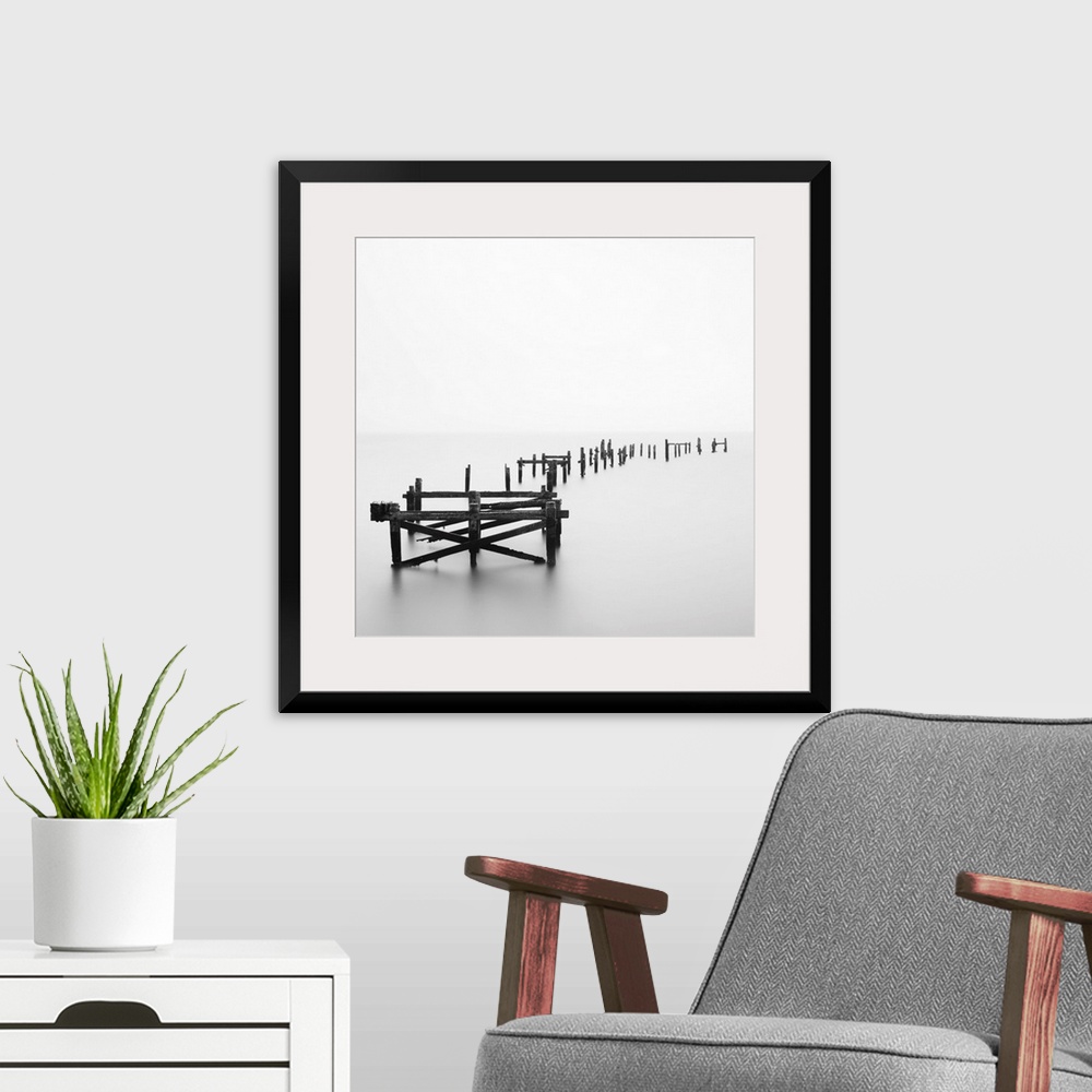 A modern room featuring Large photograph focuses on a deteriorating dock sitting alone in a wasteland of fog.