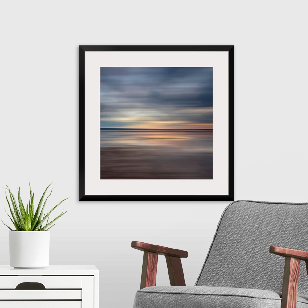 A modern room featuring Oversized fine art photograph of sunset on a horizon in horizontal streaks of warm and cool tones.
