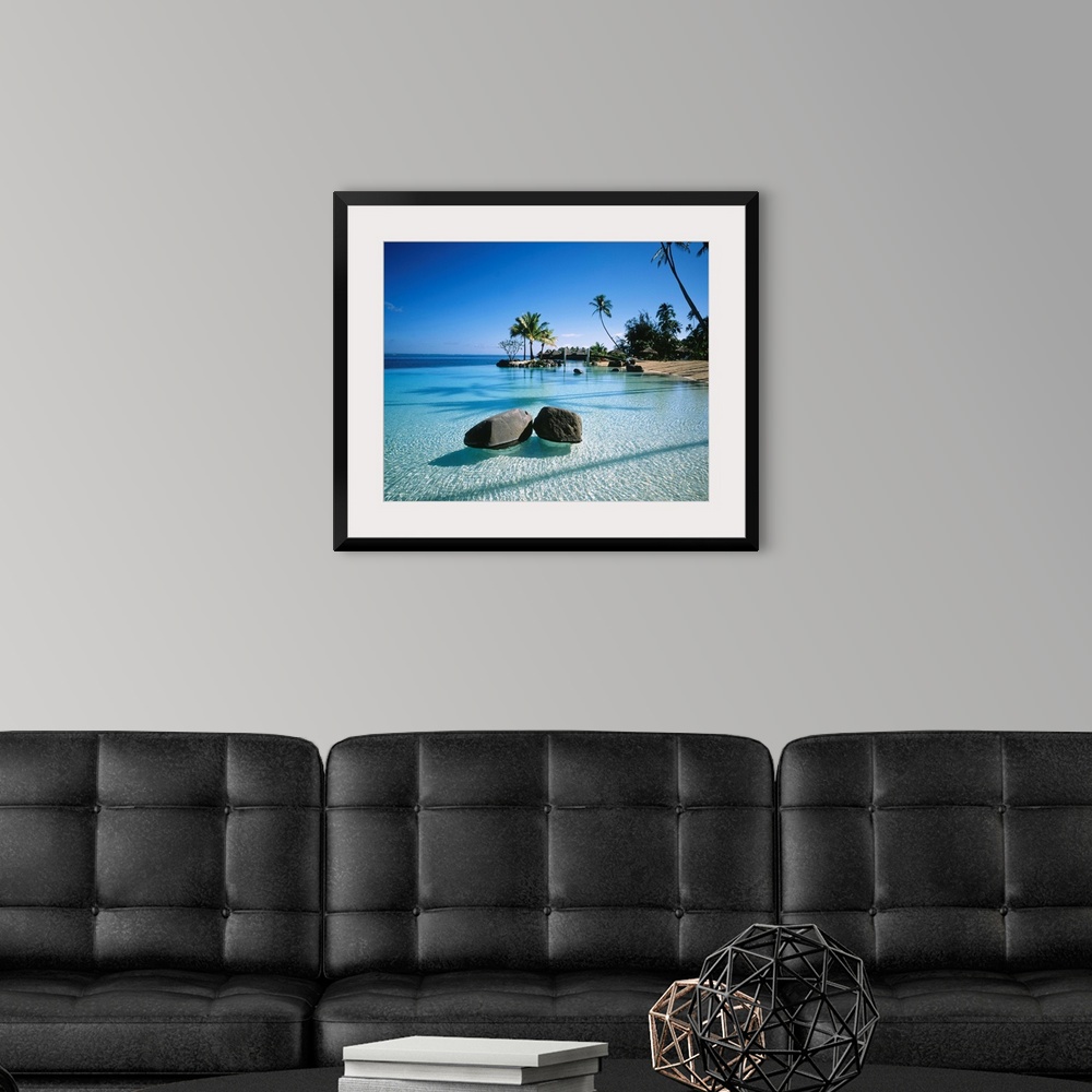 A modern room featuring Large landscape artwork for a living room or office of clear water ripples around rocks on a trop...