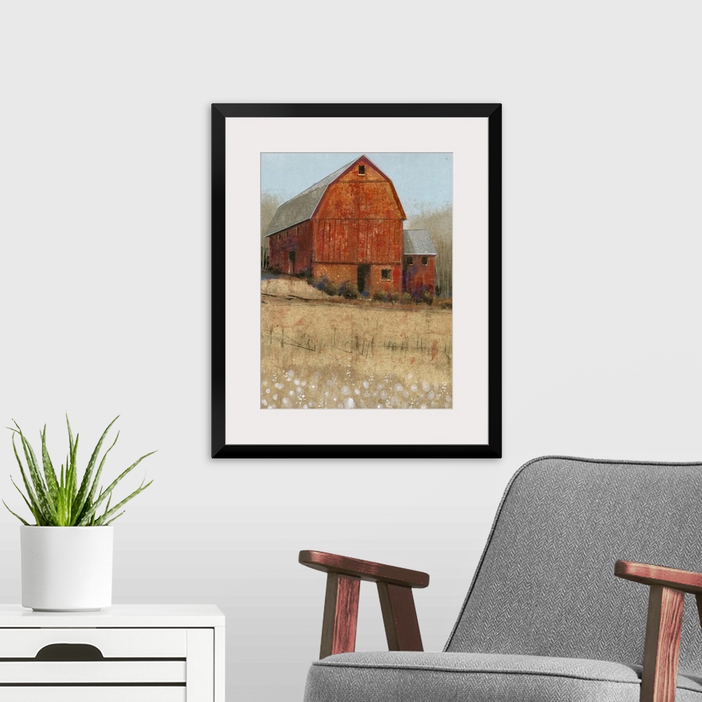 A modern room featuring Countryside artwork of rustic red barn on a straw colored field.