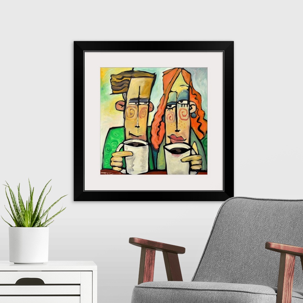 A modern room featuring Square painting of two cartoon like figures enjoying mugs of coffee.