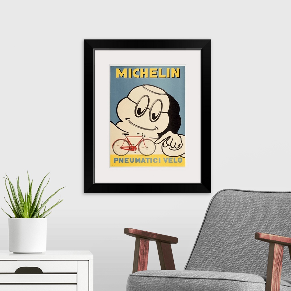 A modern room featuring Michelin man pointing to the tires on a bicycle.