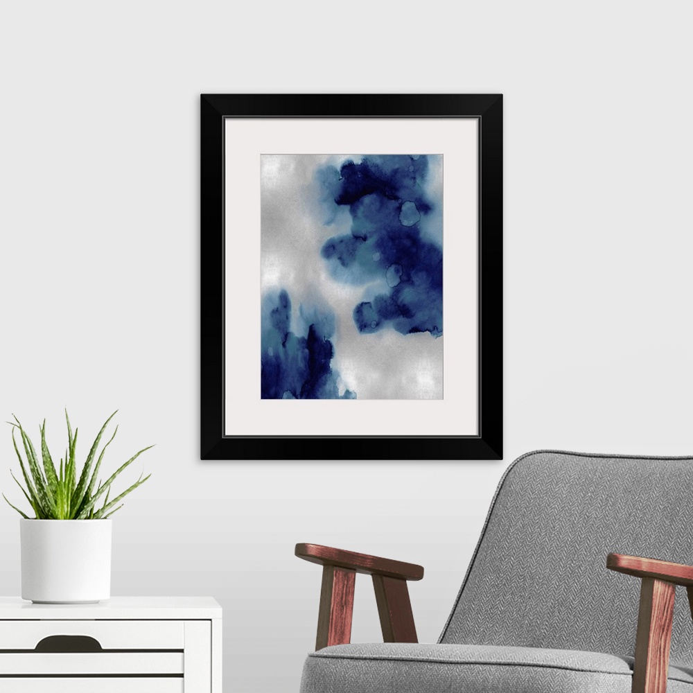 A modern room featuring Abstract painting with indigo hues splattered together on a silver background.