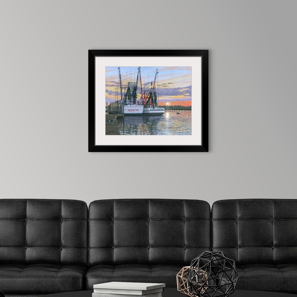 A modern room featuring Contemporary artwork of two fishing oats sitting in a harbor at sunset.