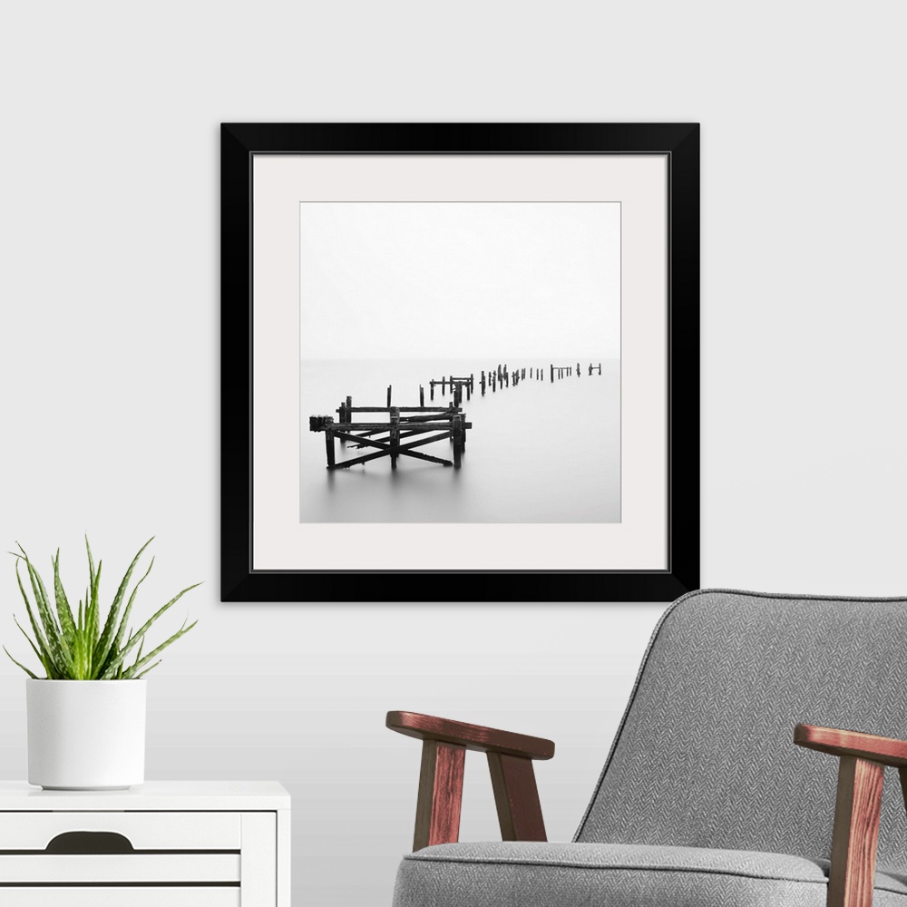 A modern room featuring Large photograph focuses on a deteriorating dock sitting alone in a wasteland of fog.