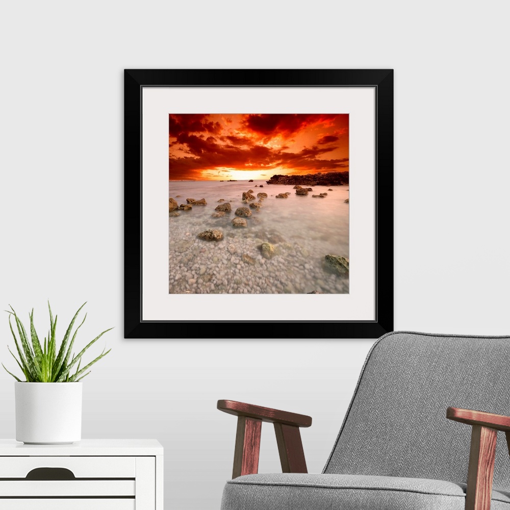 A modern room featuring Square, fine art photograph of a shallow, large body of water full of rocks, beneath a deep orang...