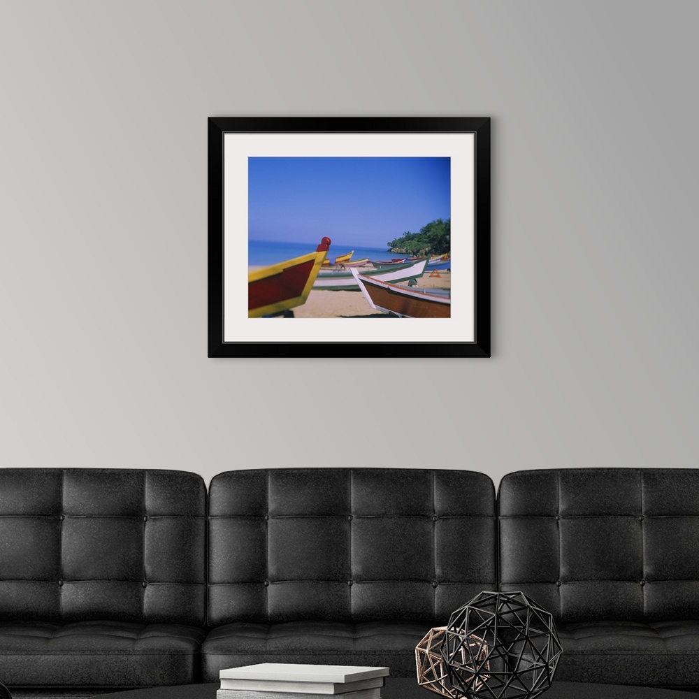 A modern room featuring Big canvas photo of colorful wooden boats sitting on a beach with an ocean in the background.