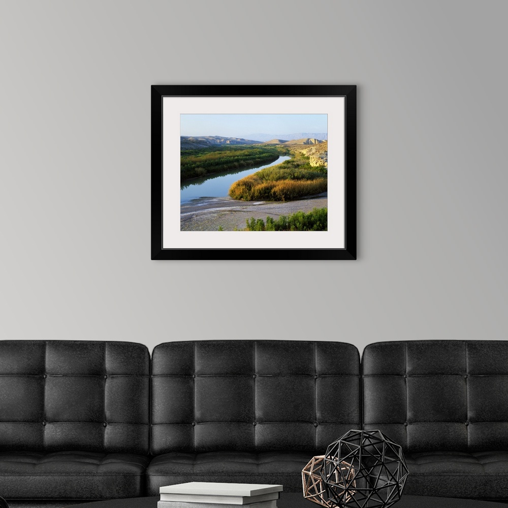 A modern room featuring This photograph was taken inside Big Bend national park showing the river that has large brush li...
