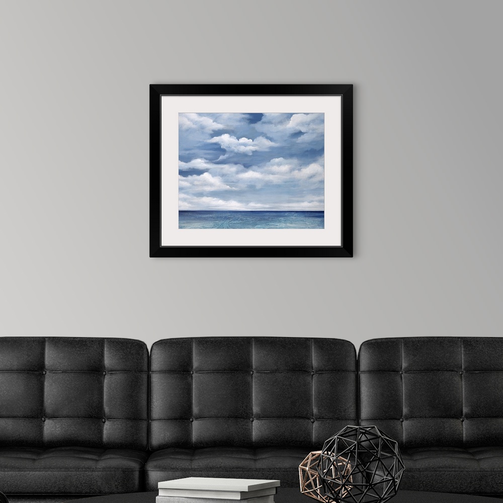 A modern room featuring Contemporary artwork of a serene ocean view with bright clouds above.