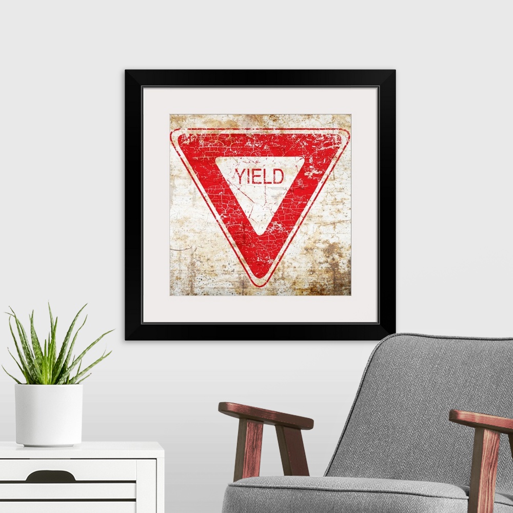 A modern room featuring A worn, distressed, cracked and rusty Yield street sign.