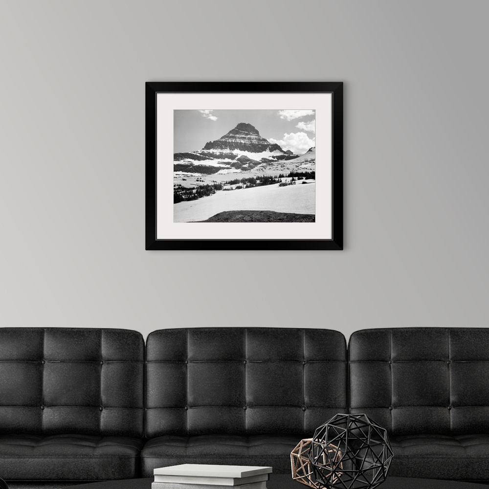 A modern room featuring From Logan Pass, Glacier National Park, looking across barren land to mountains.