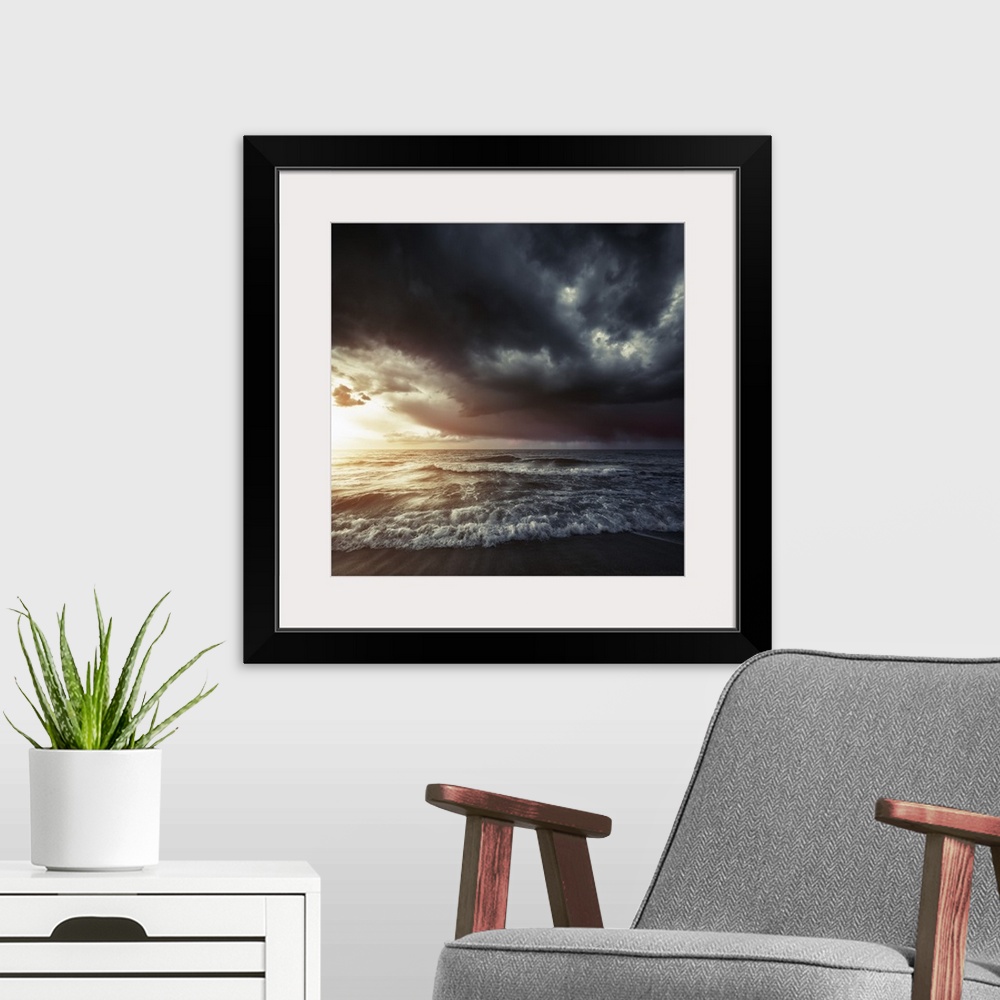 A modern room featuring Bright sunset against a wavy sea with stormy clouds, Hersonissos, Crete, Greece.